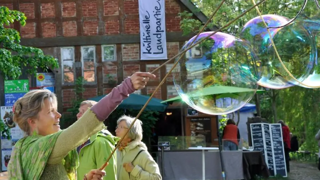 Eine-Frau-macht-im-Rahmen-der-Kulturellen-Landpartie-ein-paar-riesige-Seifenblasen