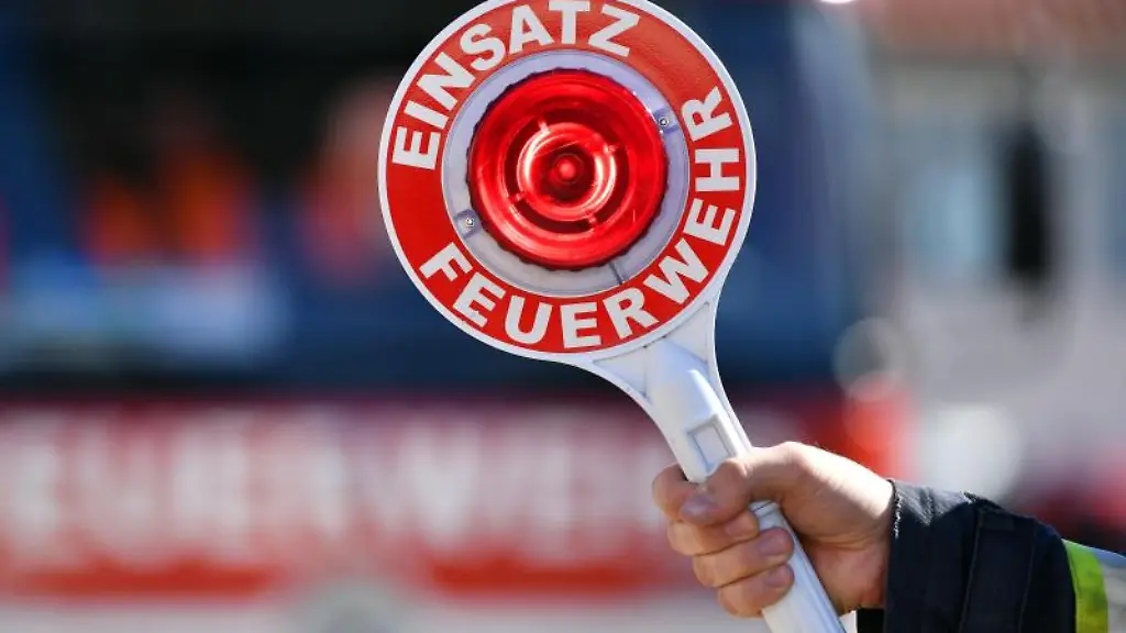 Ein-Feuerwehrmann-haelt-eine-Winkerkelle-mit-der-Aufschrift-Einsatz-Feuerwehr