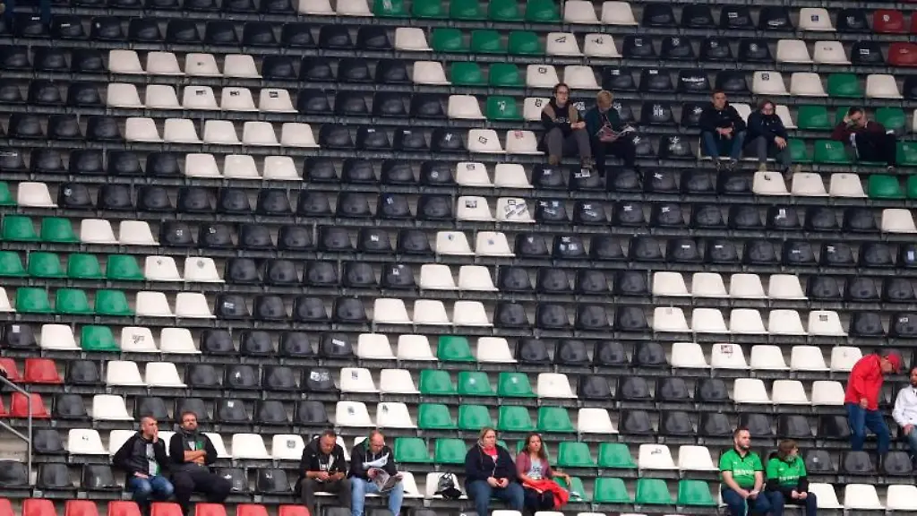 Fans-sitzen-vereinzelt-auf-der-Tribuene-mit-dem-Logo-von-Hannover-96