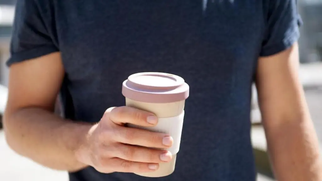 Eine-Frau-haelt-einen-Becher-in-der-Hand
