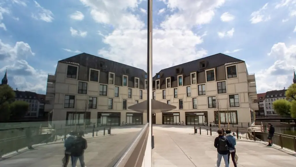 Passanten-spiegeln-sich-in-einer-Scheibe-des-Zukunftsmuseums-in-Nuernberg