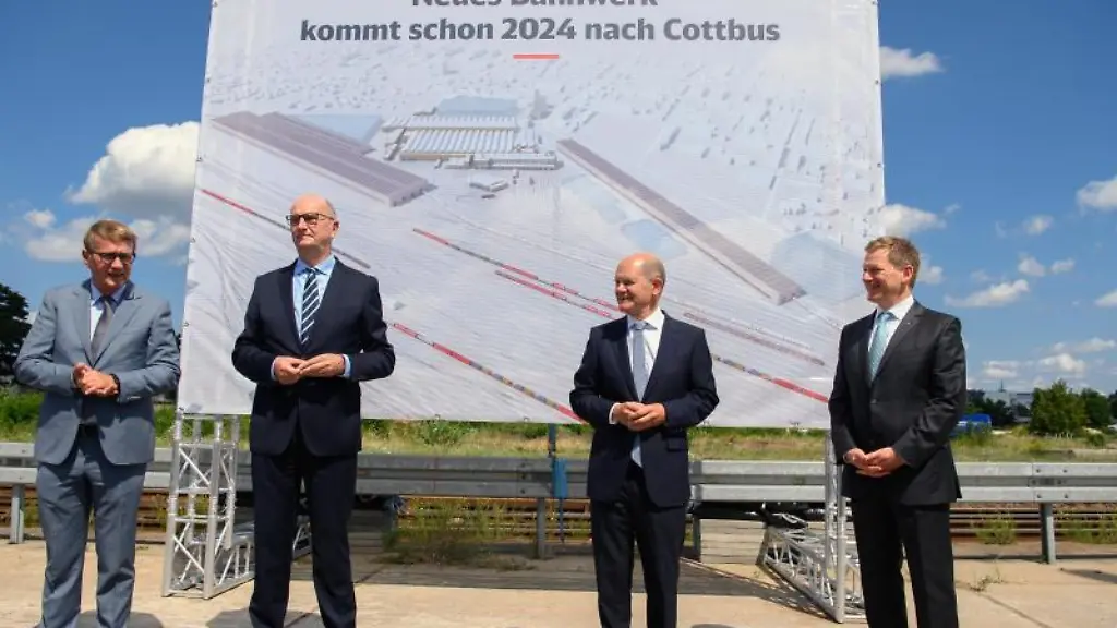 Vorstellung-der-Plaene-zum-neuen-ICE-Instandhaltungswerk-vor-einem-Plakat-mit-der-Aufschrift-Neues-Bahnwerk-kommt-schon-2024-nach-Cottbus