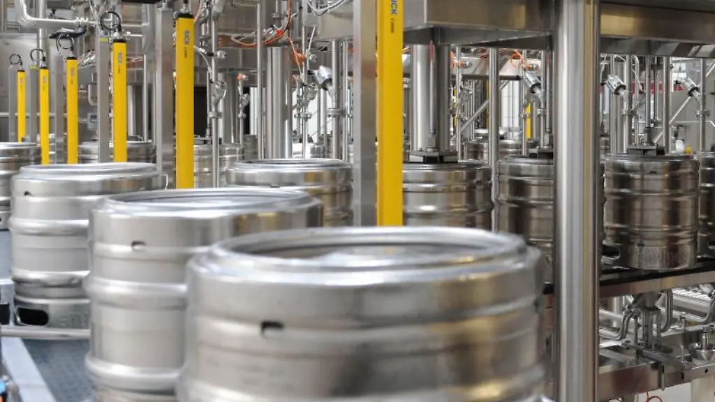 Bier-wird-in-einer-Brauerei-in-einer-Abfuellanlage-in-Bierfaesser-gefuellt