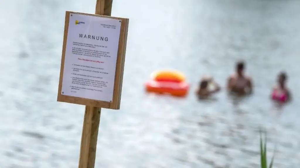 Ein-Schild-an-einem-See-warnt-vor-Blaualgen