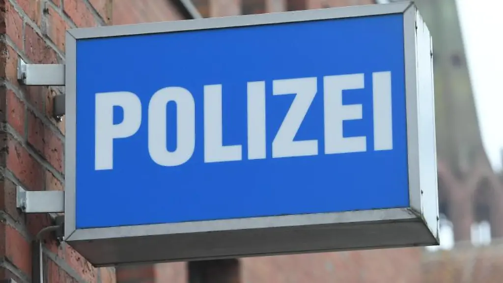 Ein-Schild-mit-dem-Schriftzug-Polizei-haengt-an-einer-Polizeiwache