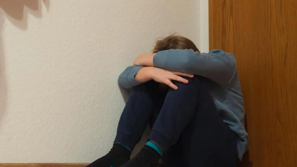 Ein-Junge-kauert-sich-in-der-Ecke-seines-Zimmers-zusammen