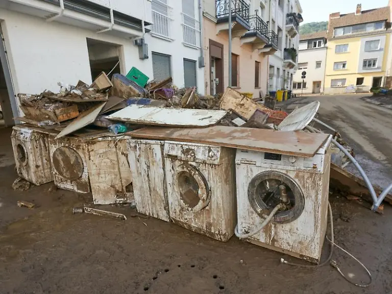 Zerstoerte-Waschmaschinen-stehen-vor-einem-Wohnhaus