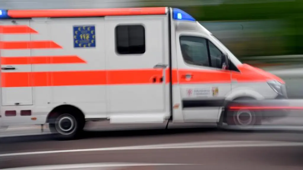 Ein-Krankenwagen-faehrt-mit-Blaulicht-auf-einer-Strasse