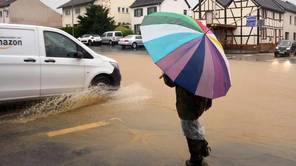 Eine-Person-laeuft-mit-einem-Schirm-durch-Gelsdorf