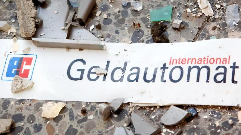 Splitter-und-ein-Schild-mit-der-Aufschrift-Geldautomat-liegen-auf-dem-Boden-vor-einem-gesprengten-Geldautomaten