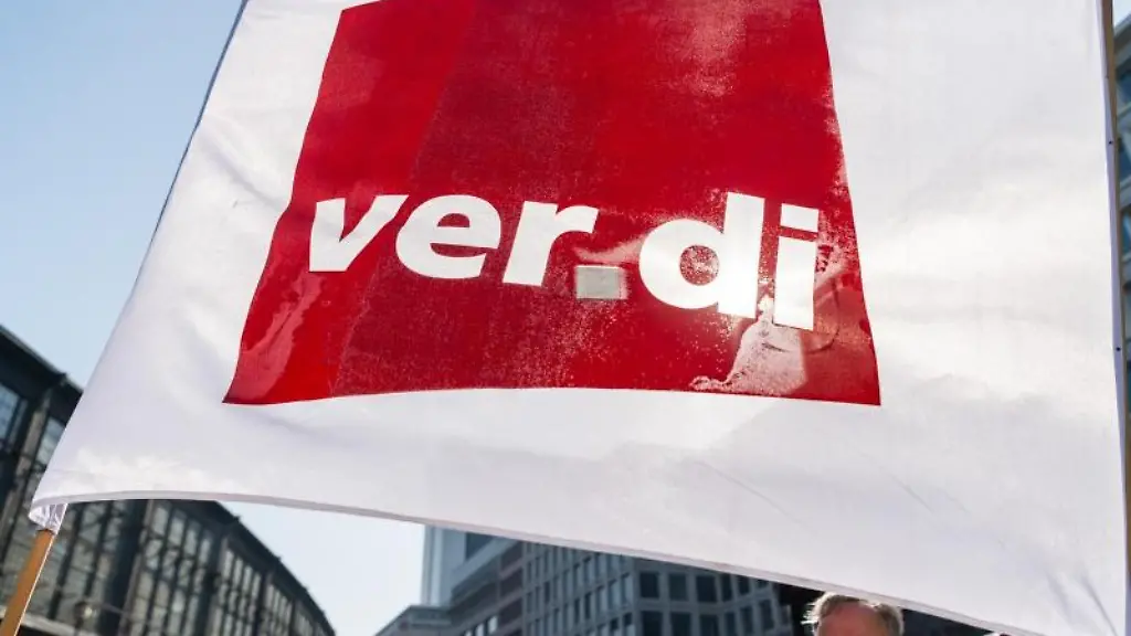 Ein-Teilnehmer-eines-Streiks-schwenkt-eine-Flagge-der-Gewerkschaft-Verdi