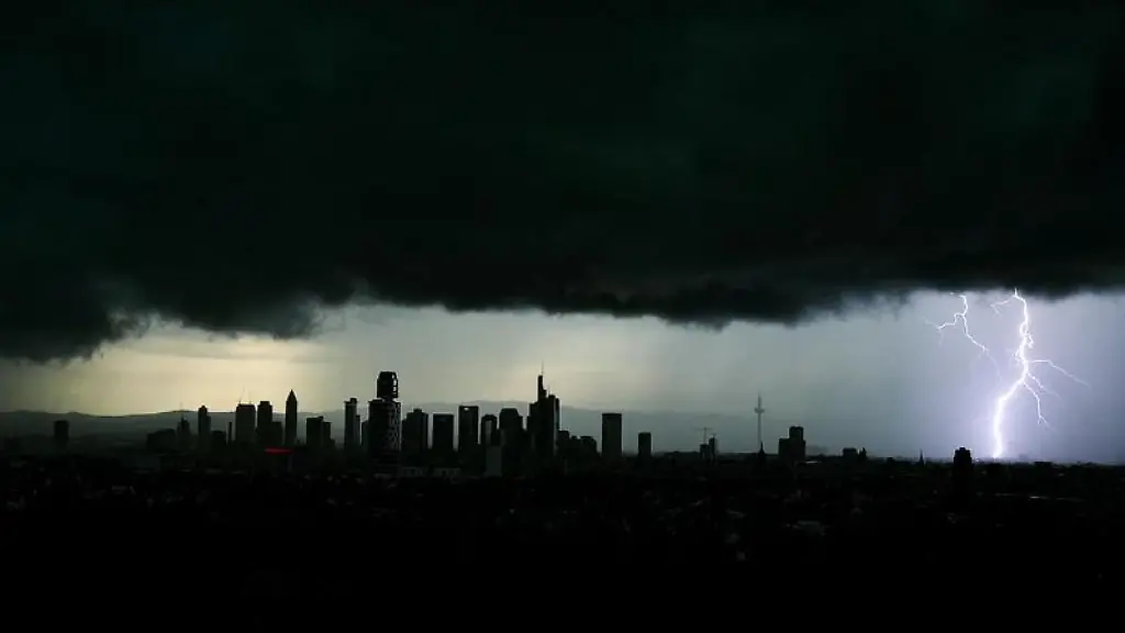 Tiefschwarze-Gewitterwolken-verdunkeln-den-Himmel-ueber-der-Frankfurter-Innenstadt-und-seinen-markanten-Hochhaeusern-waehrend-sich-ein-Blitz-entlaedt