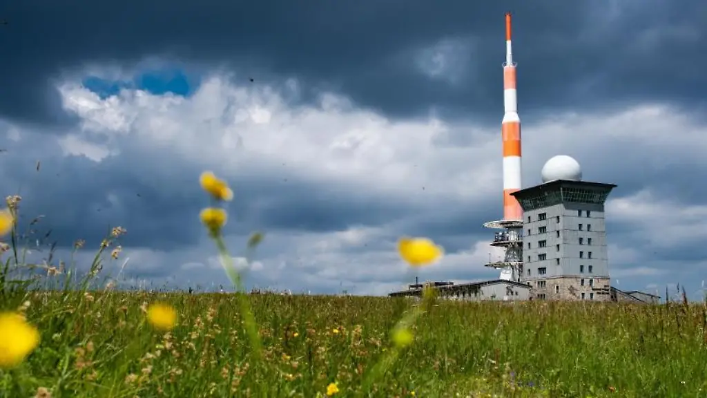 Dunkle-Wolken-ziehen-ueber-die-Brockenherberge-mit-Funkturm-auf-dem-Brocken-im-Harz