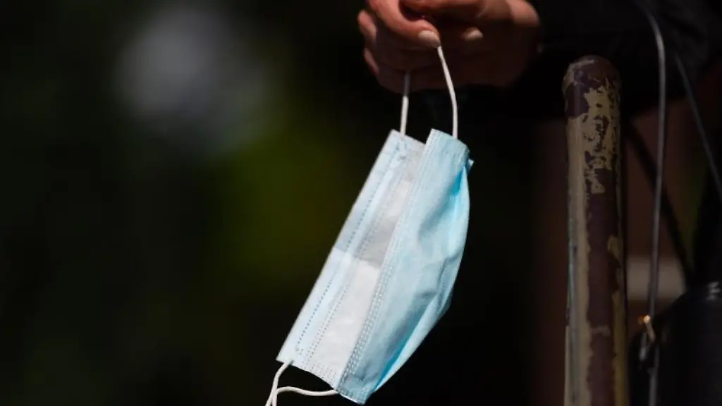 Ein-Frau-haelt-ihren-Mundschutz-in-der-Hand