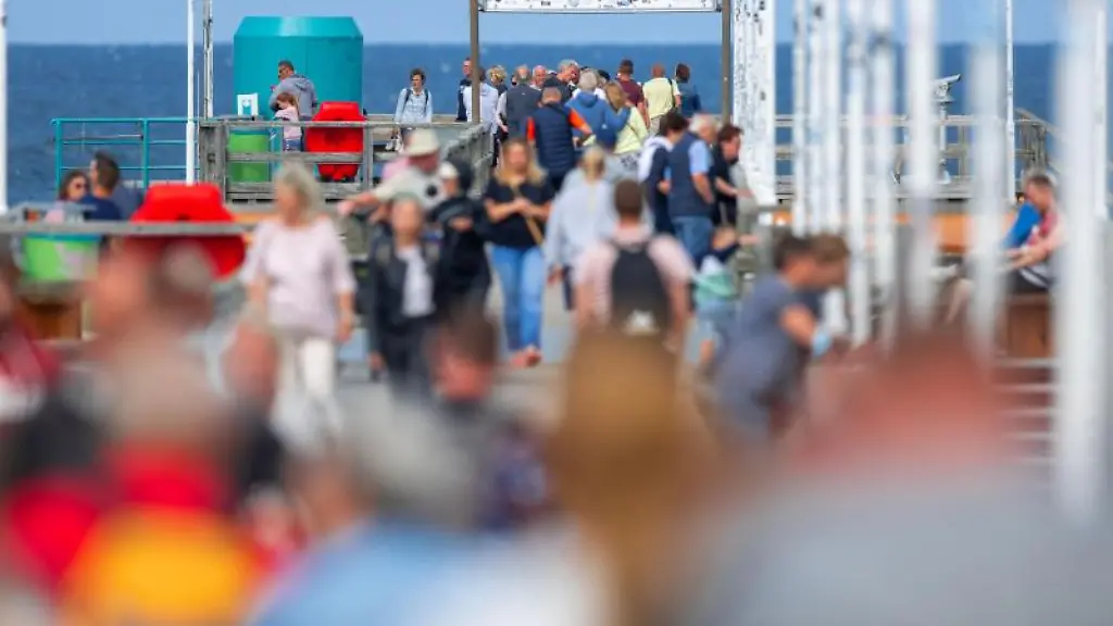 Urlauber-und-Tagesgaeste-sind-bei-teilweise-sonnigem-Wetter-auf-der-Seebruecke-auf-der-Ostseeinsel-Usedom-unterwegs