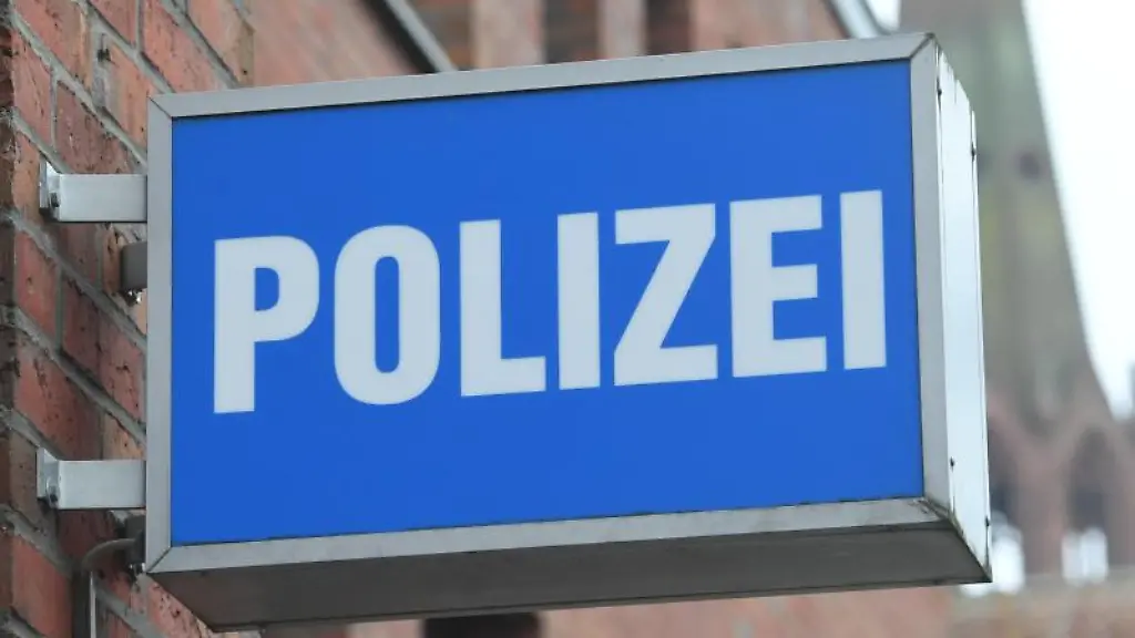 Ein-Schild-mit-dem-Schriftzug-Polizei-haengt-an-einer-Polizeiwache