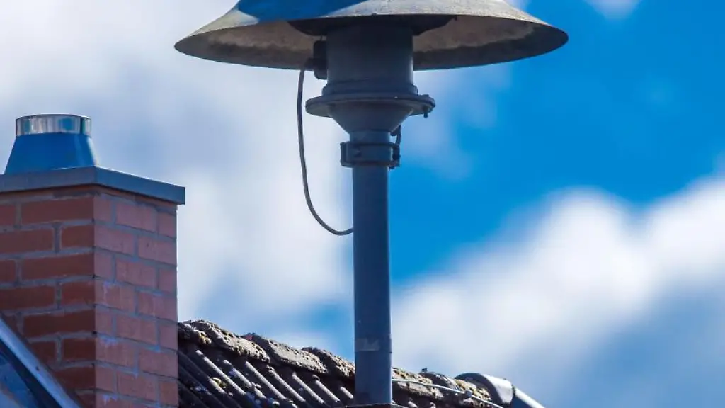 Eine-Alarmsirene-steht-auf-einem-Hausdach