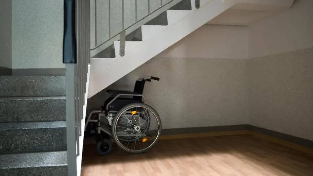 Ein-Rollstuhl-steht-unter-einer-Treppe-in-einem-Wohnhaus-in-Sachsen