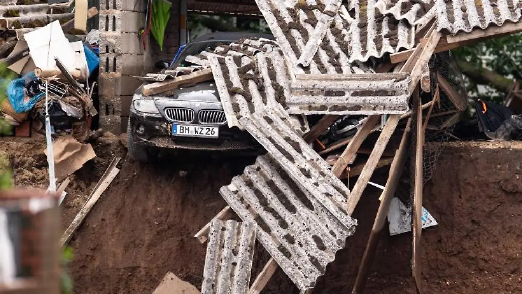 Ein-Auto-steht-in-den-Truemmern-eines-zerstoerten-Gebaeudes-im-Ortsteil-Blessem