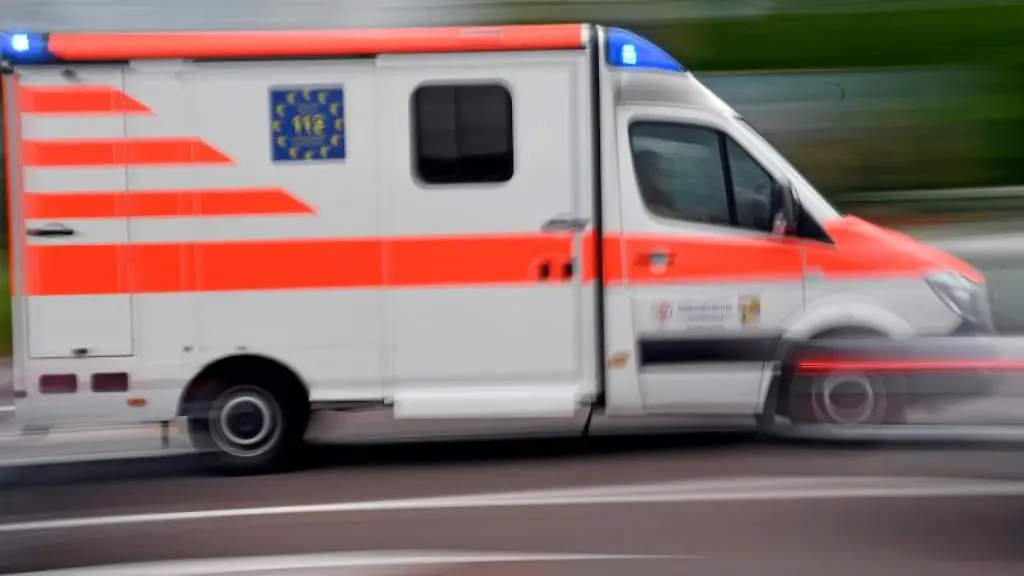 Ein-Krankenwagen-faehrt-mit-Blaulicht-auf-einer-Strasse