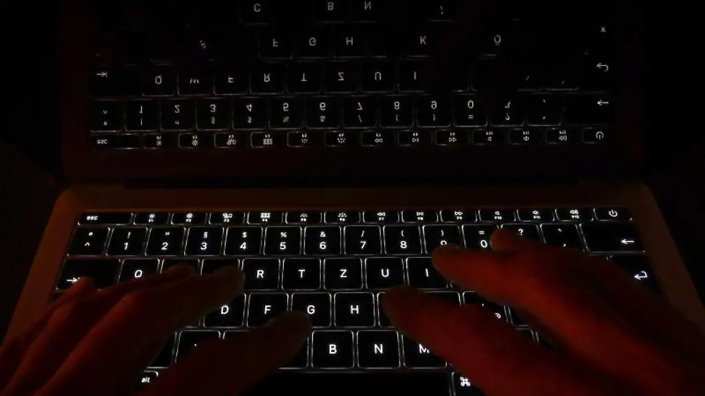 Haende-liegen-auf-der-leuchtenden-Tastatur-eines-Laptops