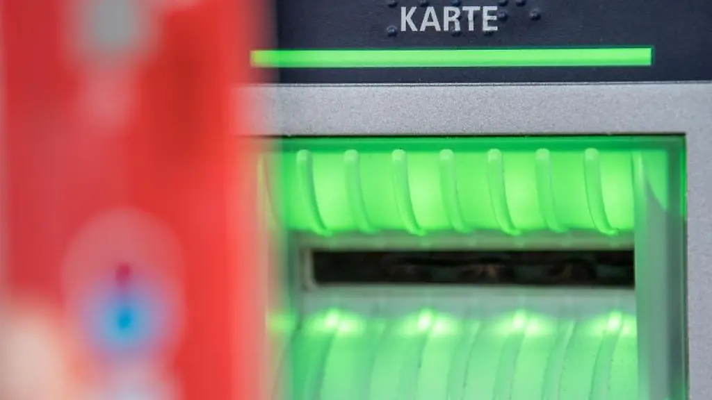 Eine-Bankkundin-hebt-mit-ihrer-Girokarte-Bargeld-von-einem-Geldautomaten-ab