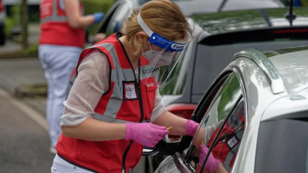 Eine-Mitarbeiterin-spritzt-bei-einer-Drive-in-Impfaktion-eine-Dosis-in-den-Arm-eines-Fahrers