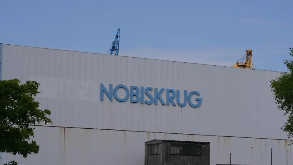 Eine-Halle-mit-dem-Firmenlogo-auf-dem-Gelaende-der-Nobiskrug-Werft