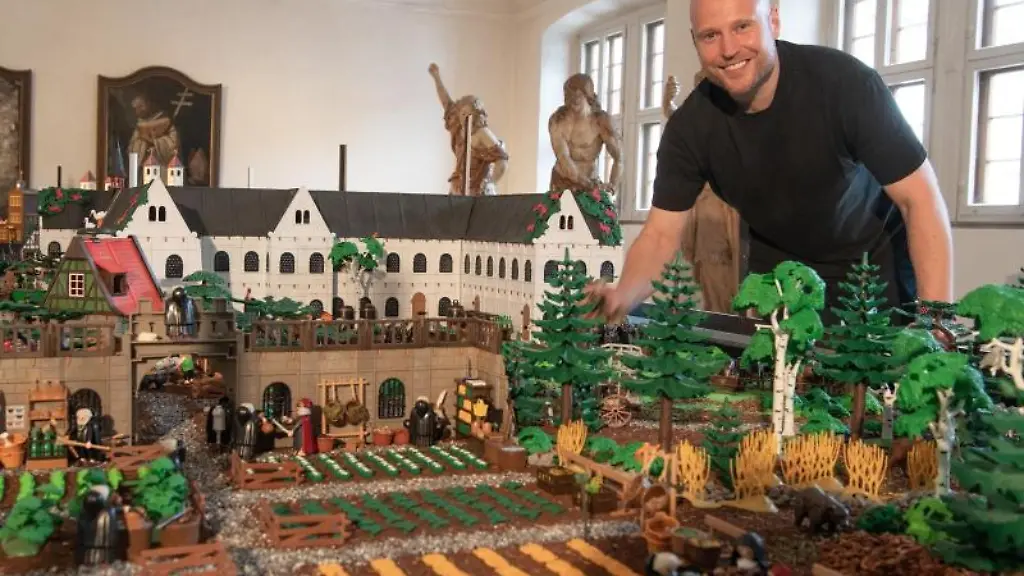 Der-Kuenstler-Oliver-Schaffer-steht-an-einem-Playmobil-Modell-des-Klosters