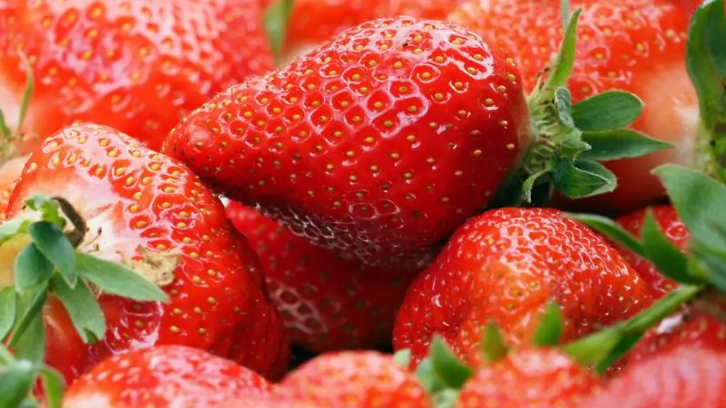 Ein-Korb-frisch-gepflueckte-Erdbeeren-steht-auf-einem-Tisch