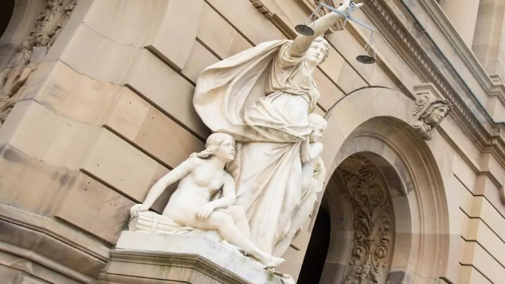 Vor-dem-Landgericht-haelt-eine-Statue-der-Justitia-eine-Waagschale