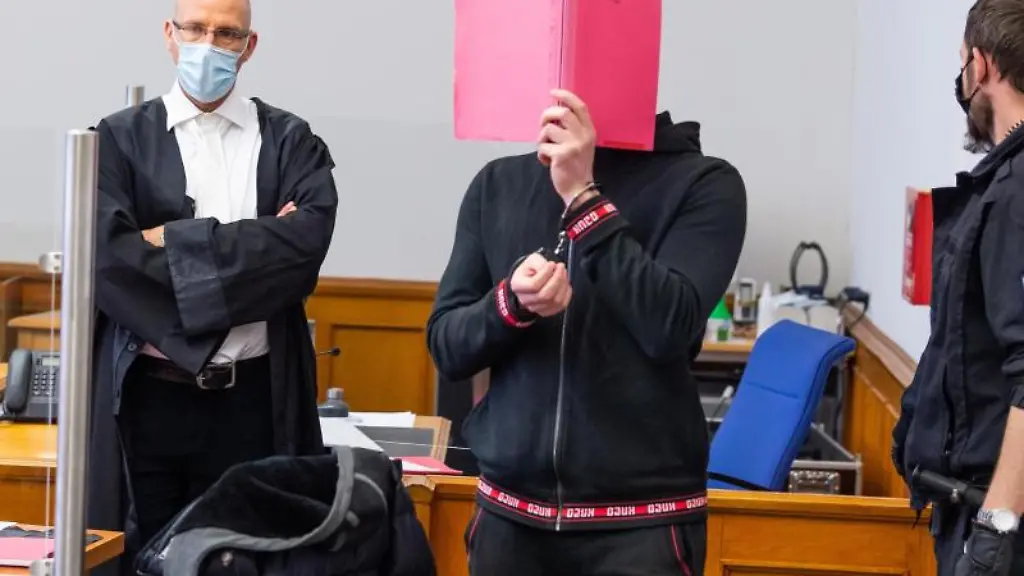 Der-Angeklagte-M-wird-zu-Prozessbeginn-in-den-Saal-vom-Landgericht-gefuehrt