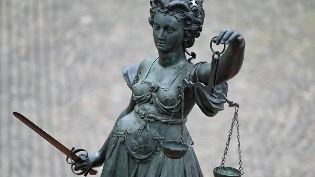 Eine-Statue-der-Justitia-haelt-eine-Waage-und-ein-Schwert-in-der-Hand