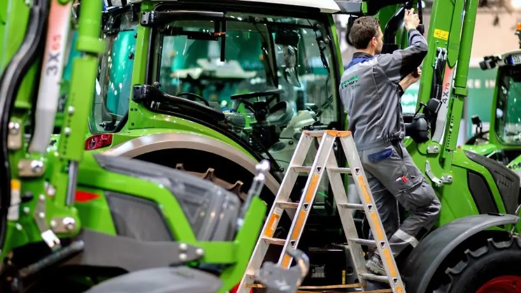 Ein-Mitarbeiter-stellt-den-Aussenspiegel-eines-Traktors-ein