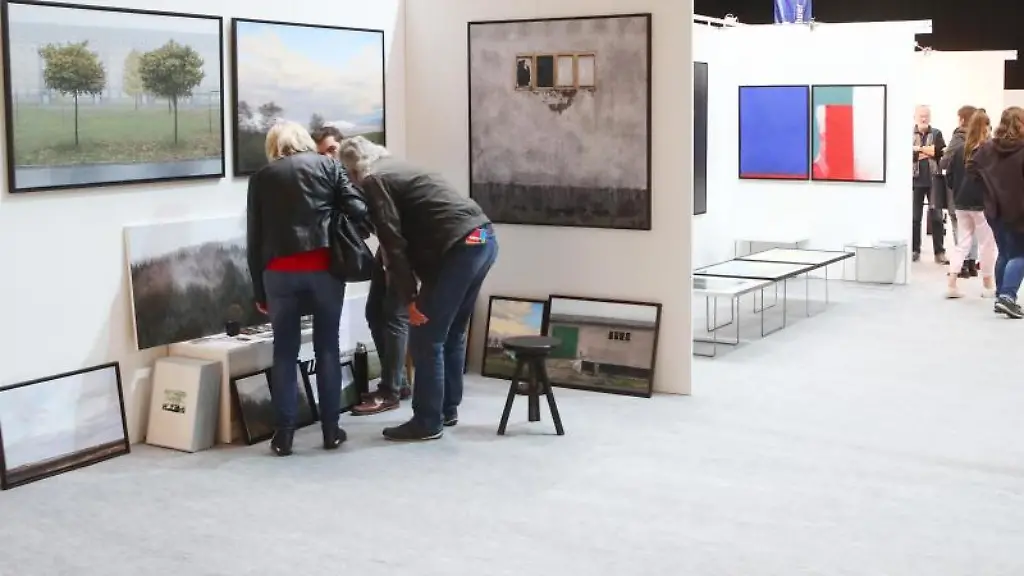 Besucher-betrachten-Gemaelde-auf-der-Kunstmesse-artthuer