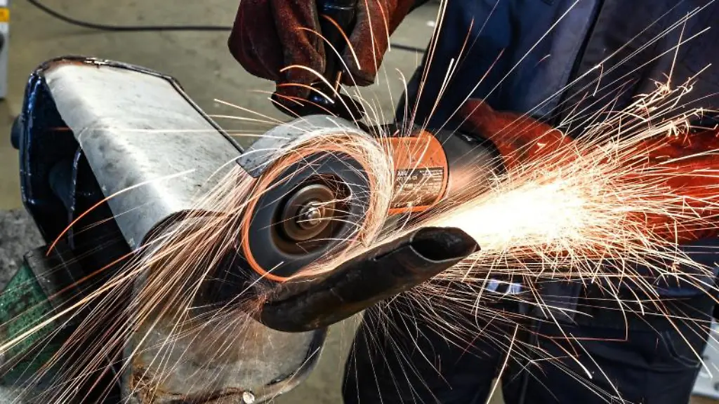 Ein-Auszubildender-im-KFZ-Handwerk-schneidet-mit-einer-Flex-einen-alten-Auspuff-auf