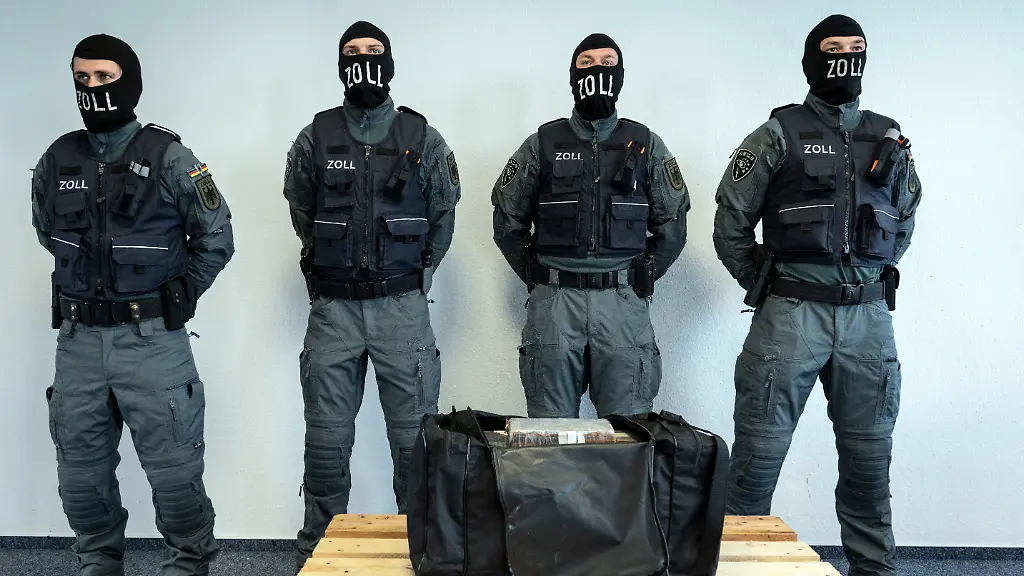 Beamte-des-Zollfahndungsamtes-Essen-stehen-hinter-einer-Tasche-mit-Kokain-Die-Tasche-stammt-aus-einer-Sicherstellung-von-451-kg-Kokain-mit-dem-Strassenverkaufswert-von-31-Millionen-Euro-im-Rheinkreis-Neuss