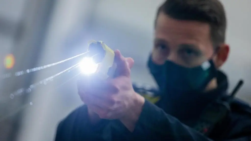 Ein-Polizeibeamter-demonstriert-einen-Schuss-mit-einem-Distanzelektroimpulsgeraet