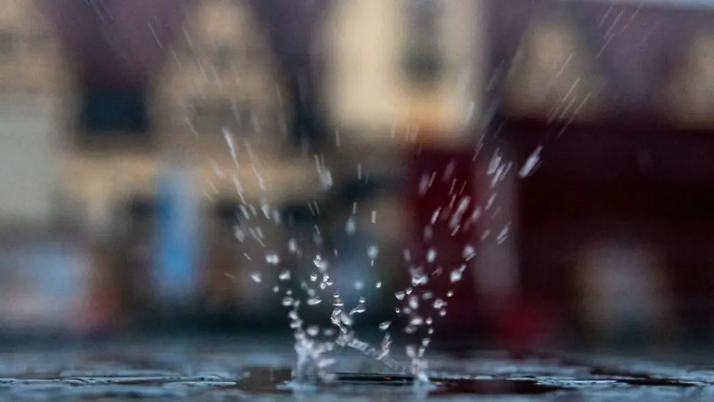 Ein-Regentropfen-faellt-auf-eine-Pfuetze-auf-einem-Tisch-im-Aussenbereich-eines-Restaurants