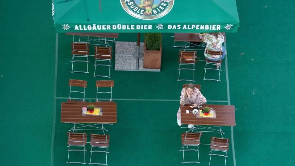 Gaeste-sitzen-in-einem-Biergarten