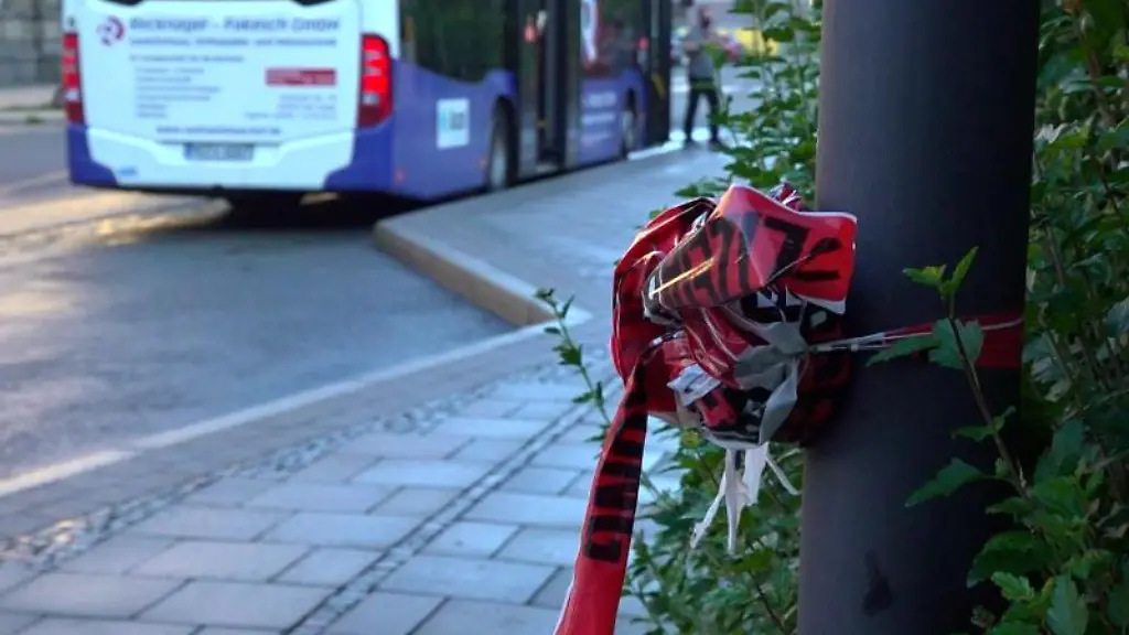 Zusammengeknotetes-Absperrband-der-Polizei-haengt-an-einem-Pfahl-einer-Bushaltestelle
