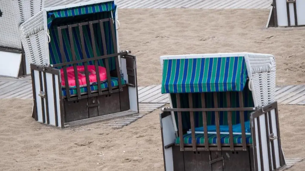 Strandkoerbe-verteilen-sich-ueber-den-Sand