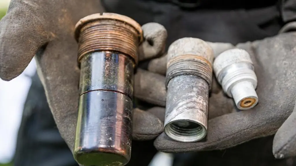 Ein-Kampfmittelraeumer-zeigt-nach-der-Entschaerfung-einer-Fliegerbombe-die-Bestandteile-ihres-entfernten-Zuenders