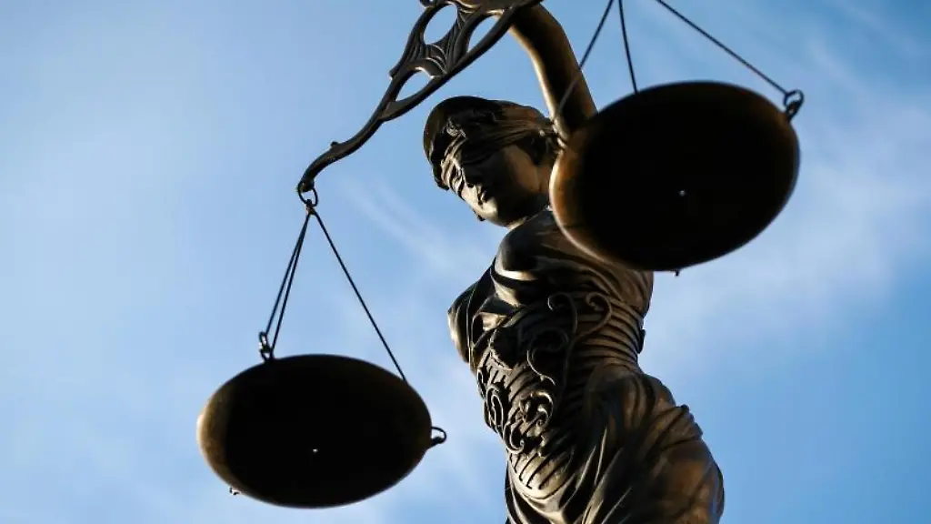 Eine-Statue-der-Justitia-haelt-eine-Waage-in-der-Hand