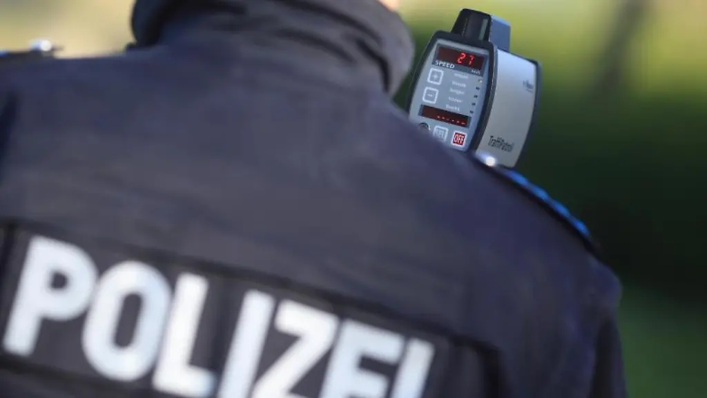 Waehrend-einer-Geschwindigkeitskontrolle-fuehrt-ein-Polizist-eine-Messung-durch