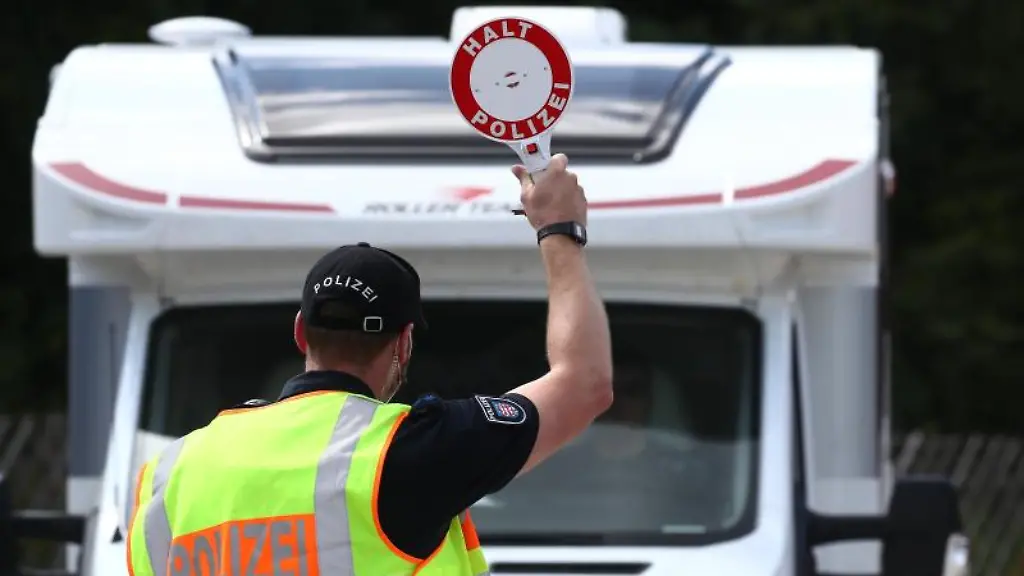 Ein-Polizeibeamter-stoppt-ein-Wohnmobil-bei-einer-Kontrolle-auf-einem-Parkplatz-an-der-A9