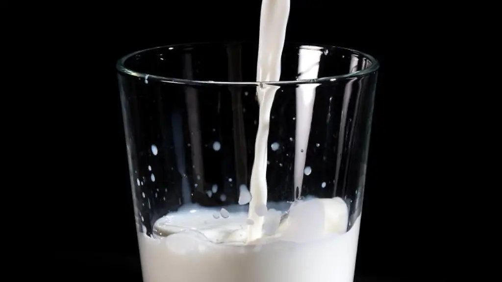 Milch-wird-in-ein-Glas-gekippt