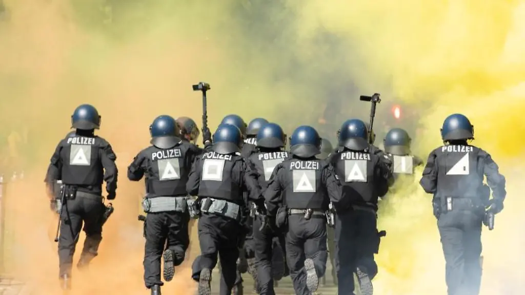 Polizisten-laufen-vor-dem-Stadion-durch-den-Nebel-von-Pyrotechnik