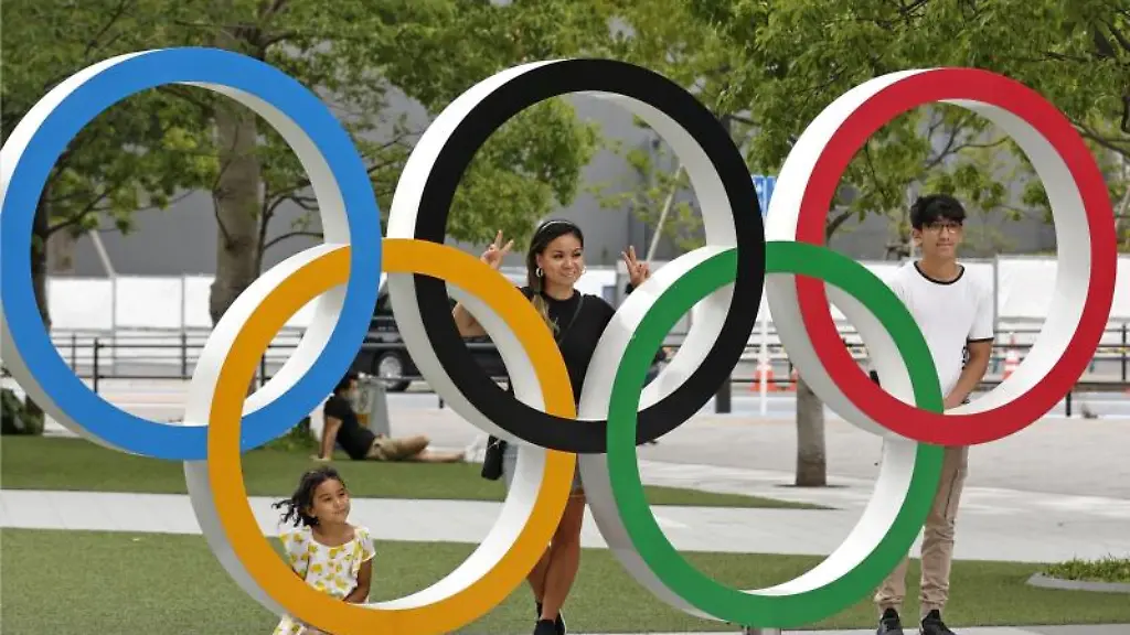 Menschen-stehen-hinter-den-Olympischen-Ringen