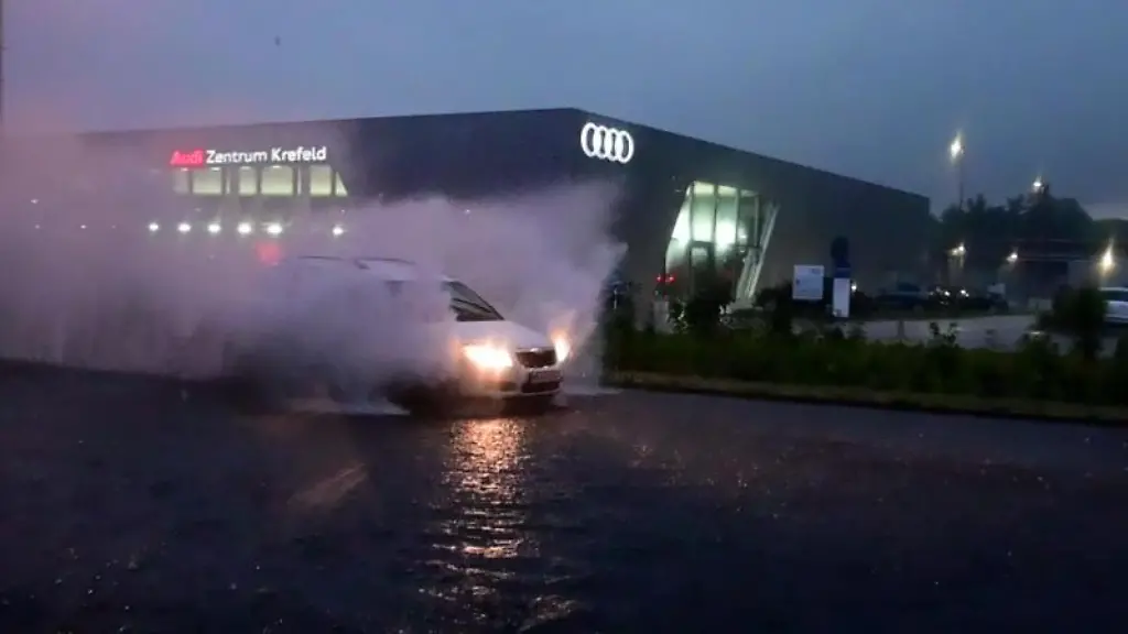 Ein-Auto-faehrt-durch-eine-ueberflutete-Strasse